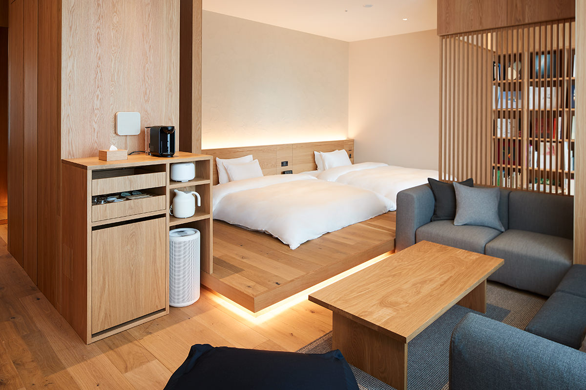MUJI Hotel Ginza Type B suite with neutral linens, salvaged cedar floors, and a corner sofa